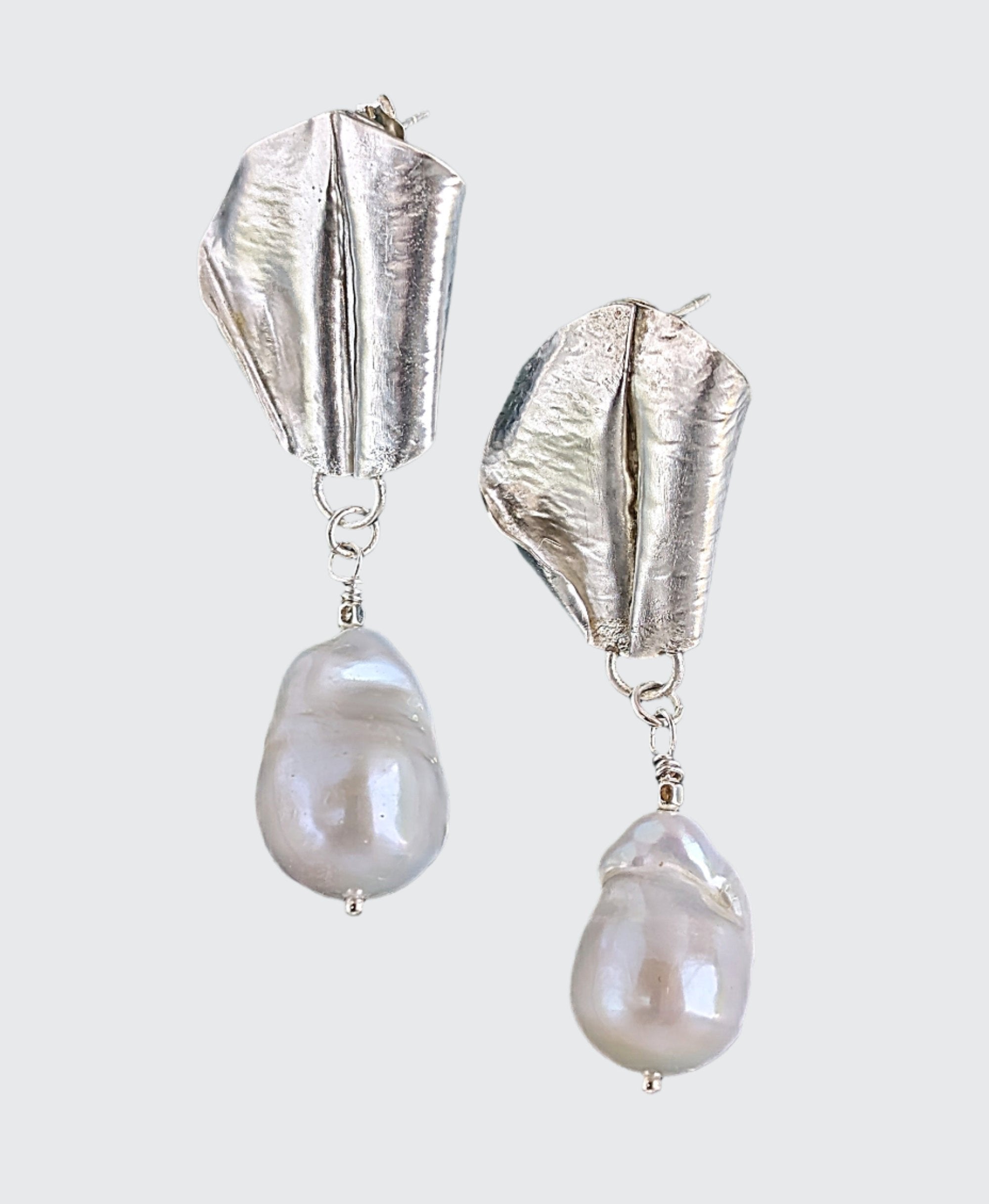 White Baroque pearl drop earrings with sterling silver fold form and hand hammered leaf design.
