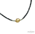 A gold-colored pendant necklace with blue faceted onyx and aqua apatite stones, displayed against a black background.