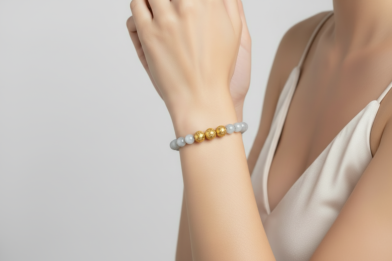 Aquamarine gemstone bracelet and Venetian lamp work gold glass beads on the arm of a model.