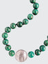A close-up image of a silver toggle clasp on a necklace with hand-knotted chrysocolla beads and lampwork glass.
