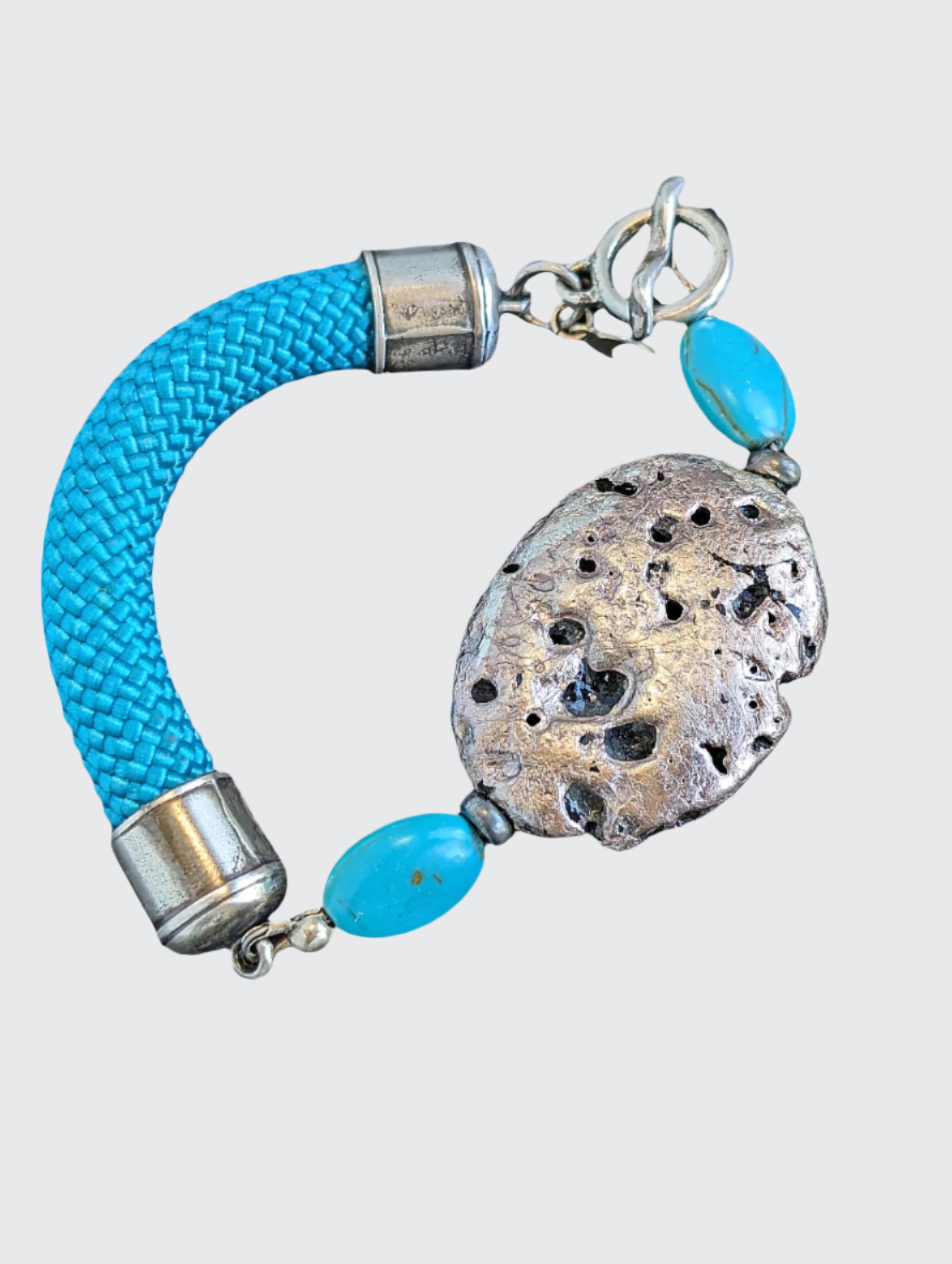 Hand gilded Silver on lava stone bracelet with sterling silver and turquoise beads, turquoise color cord, and sterling silver toggle clasp.