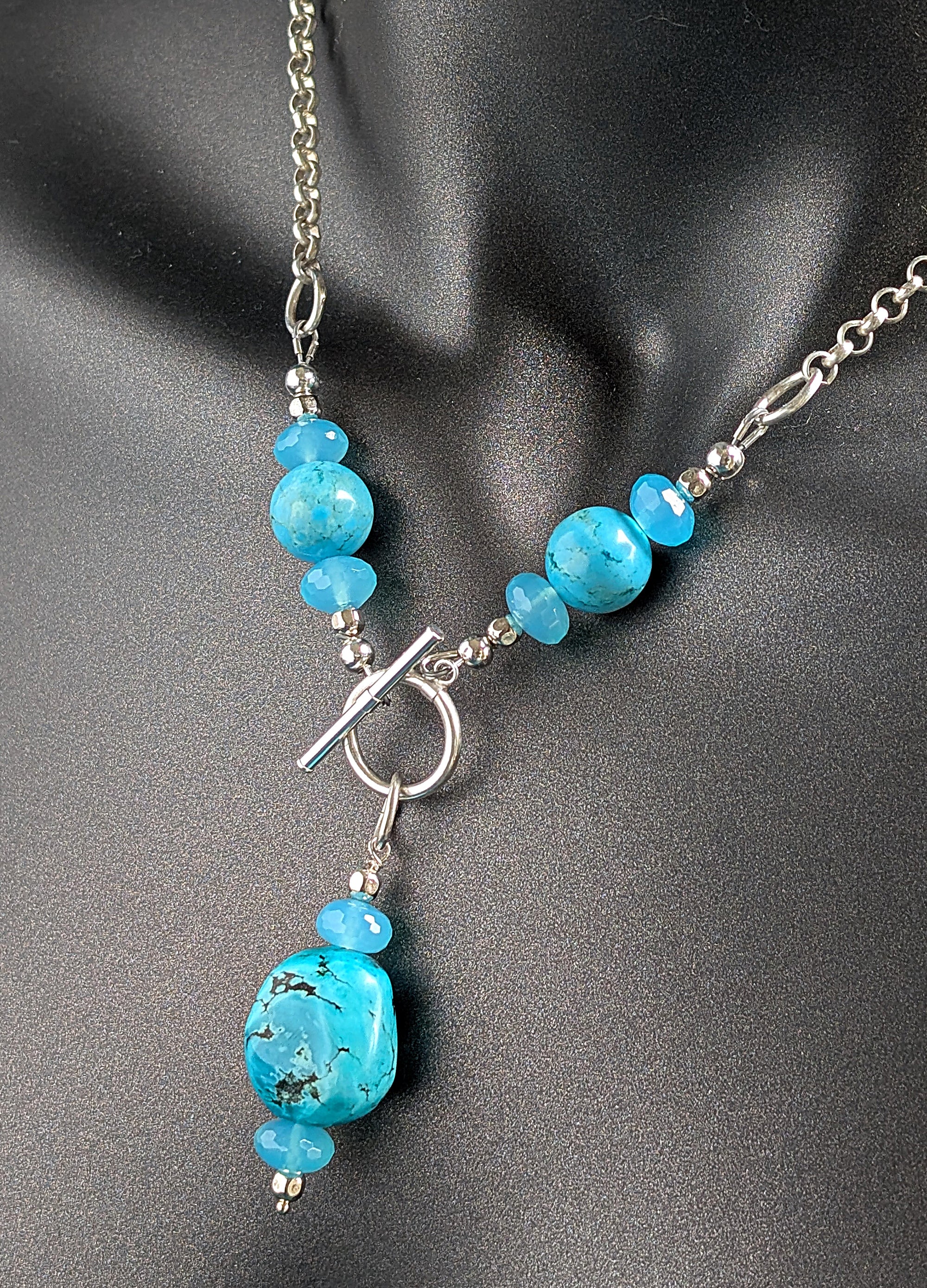 Necklace with blue beads and a silver clasp on a gray background