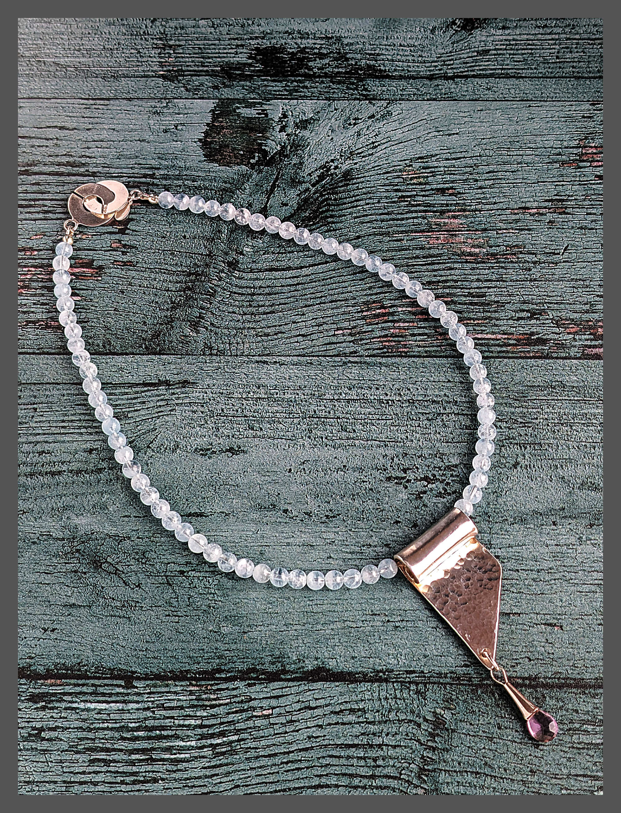 18" necklace adorned with stunning 6mm aquamarine beads. The hand-hammered sterling silver pendant beautifully captures the essence of a cascading waterfall, accentuated by a faceted ametrine gem delicately dangling as a single drop.