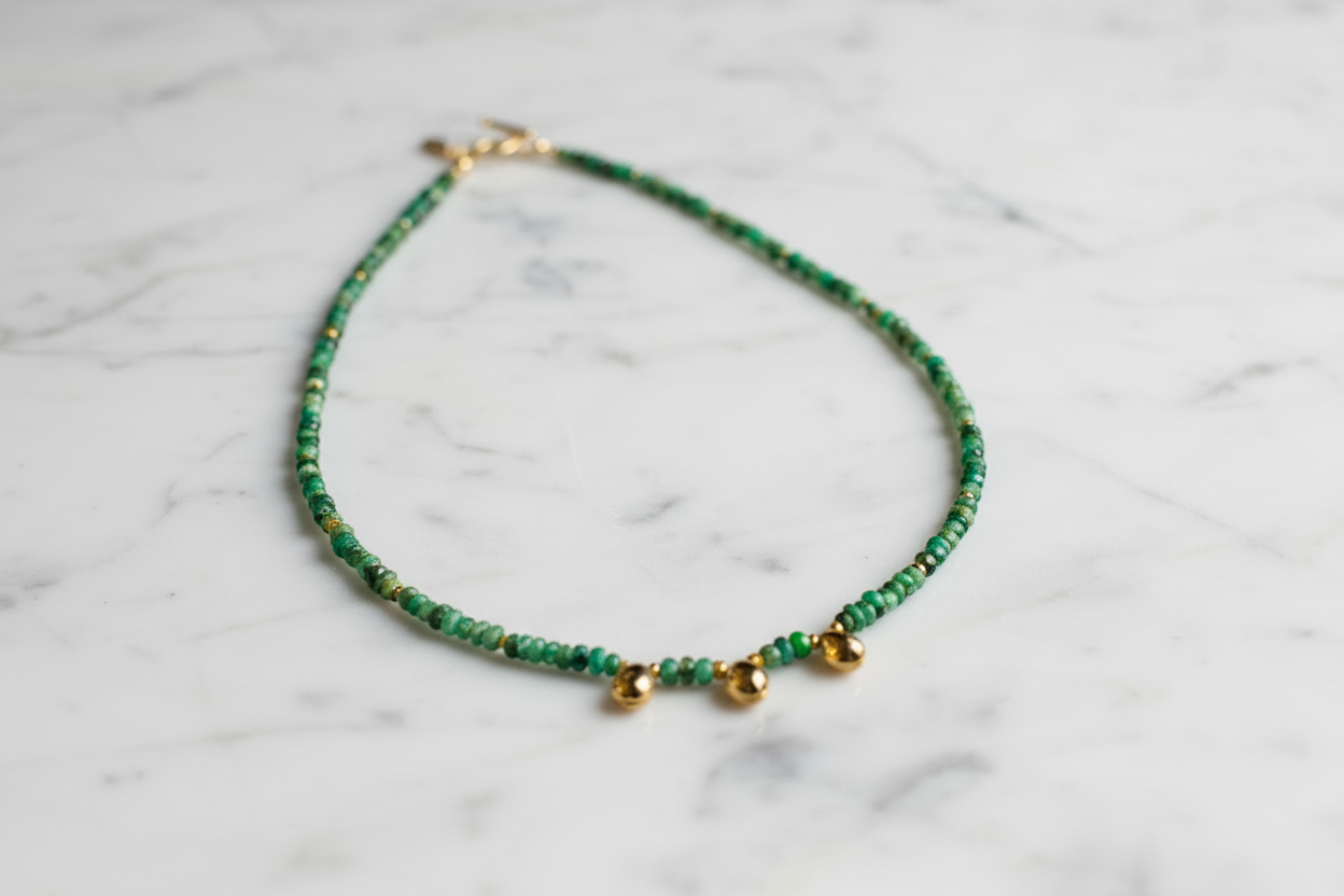 green and gold necklace on a white background.