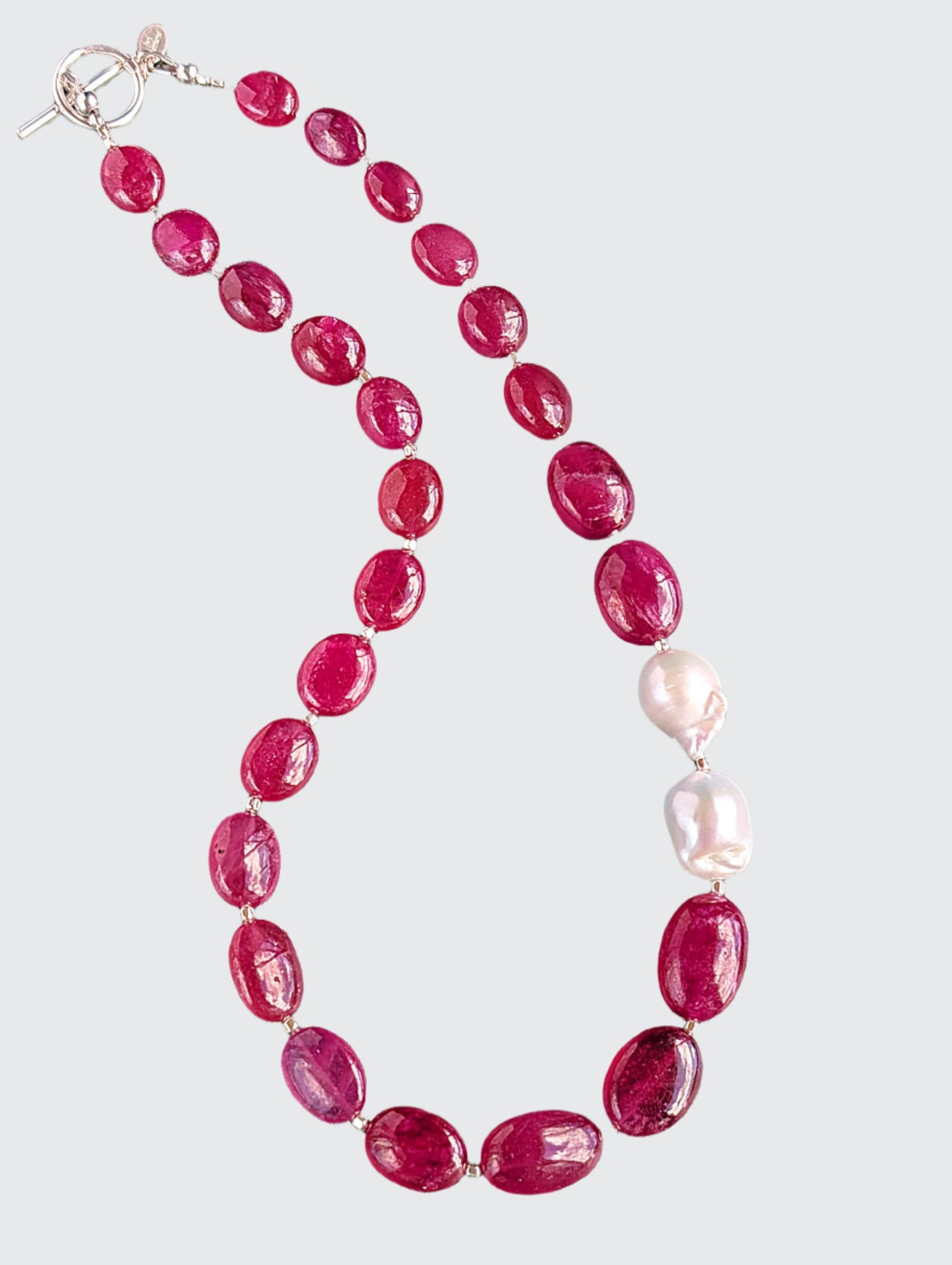 Ruby and Baroque Pearl Necklace - "Romancing the Ruby" necklace. This exquisite piece features cabochon smooth rubies, lustrous Baroque pearls, sterling silver beads, a charming toggle clasp, and a signature tag by the artist. With a length of 18 inches.