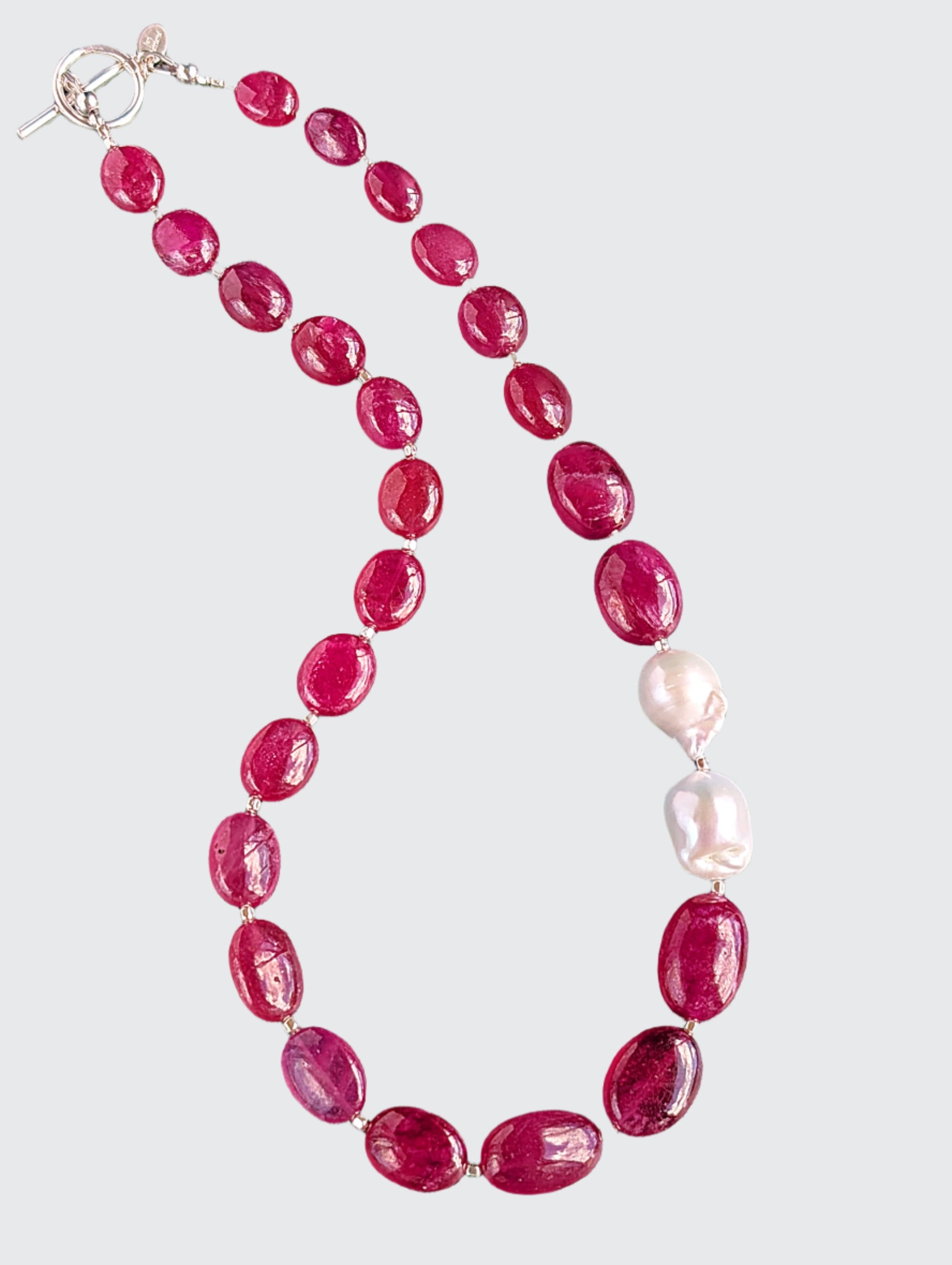 Ruby and Baroque Pearl Necklace - "Romancing the Ruby" necklace. This exquisite piece features cabochon smooth rubies, lustrous Baroque pearls, sterling silver beads, a charming toggle clasp, and a signature tag by the artist. With a length of 18 inches.