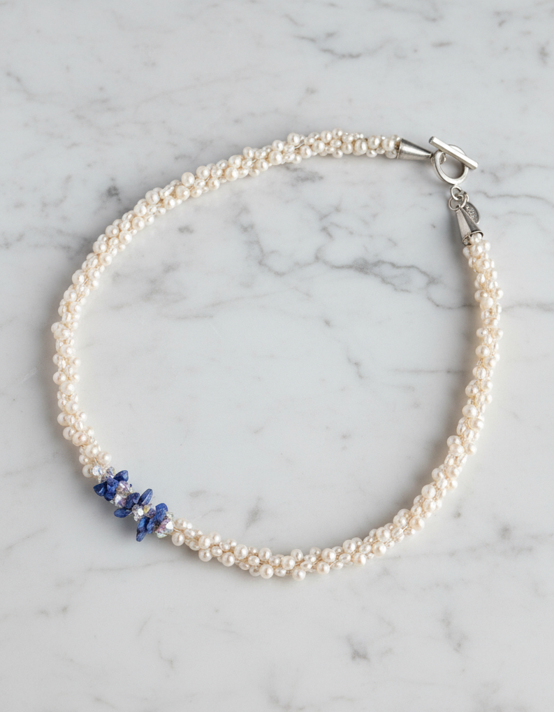 "Something Blue" necklace is a combination of glowing cultured freshwater pearls with center stones in gorgeous lapis lazuli and sparkly Swarovski crystals. The beads are braided on 8 strands to create an elegant heirloom-quality necklace