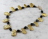 A luxurious necklace featuring hand-gilded luminous gold on lava stone, with a variety of shapes and sizes of gold-leaf-covered stones, and a gold-filled toggle clasp.