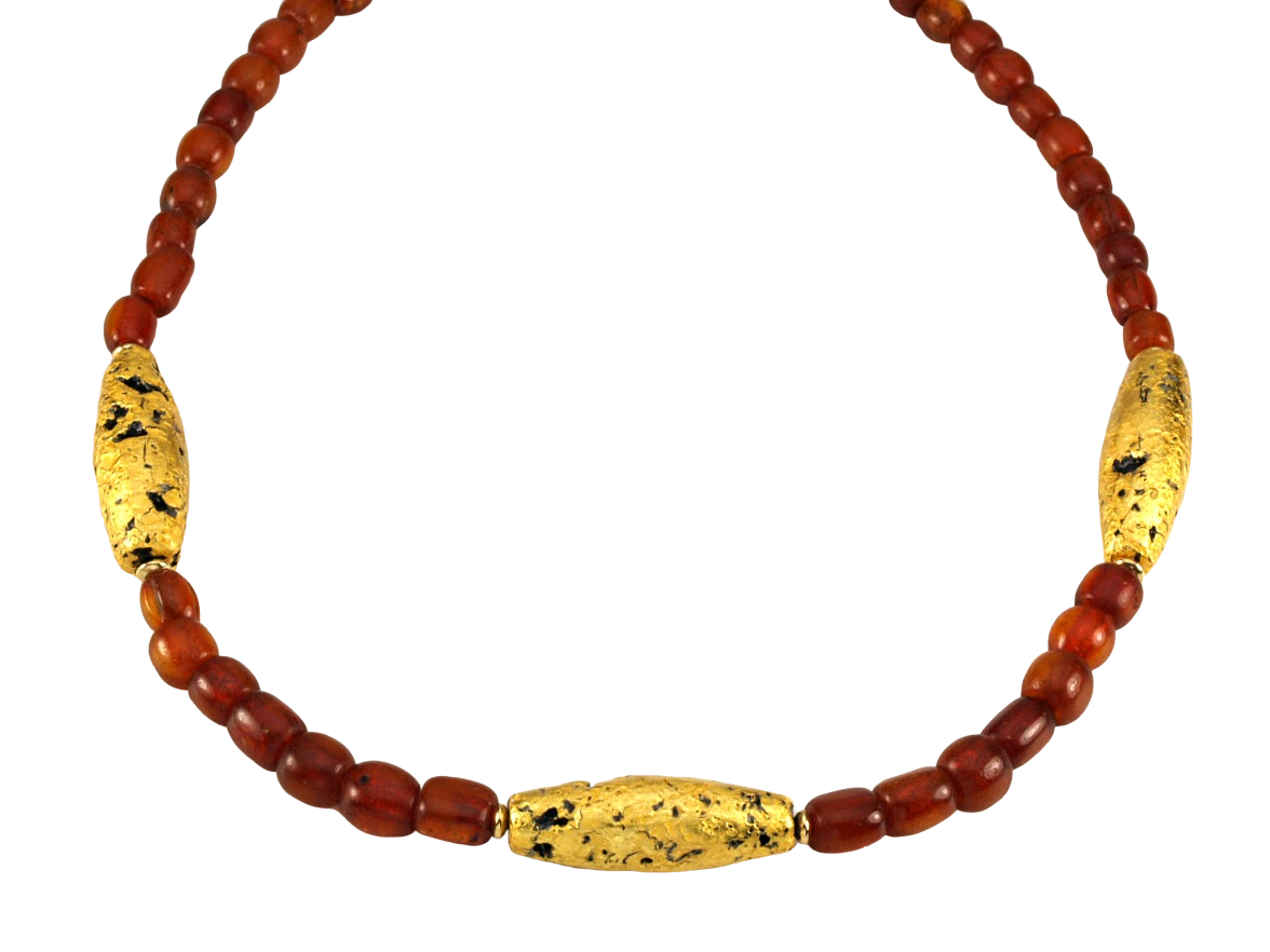 Necklace with three gold gilded oblong lava beads evenly spaced between pecan colored amber beads laid out in a circle close up.