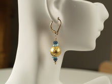 Load image into Gallery viewer, 4mm faceted dark blue onyx, aqua apatite, and 23 karat gold gilded round lava stone with 14-karat gf leverback earrings on a small mannequin.