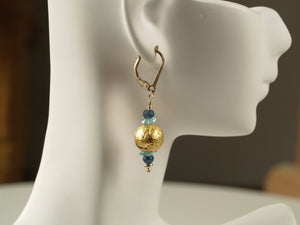 4mm faceted dark blue onyx, aqua apatite, and 23 karat gold gilded round lava stone with 14-karat gf leverback earrings on a small mannequin.