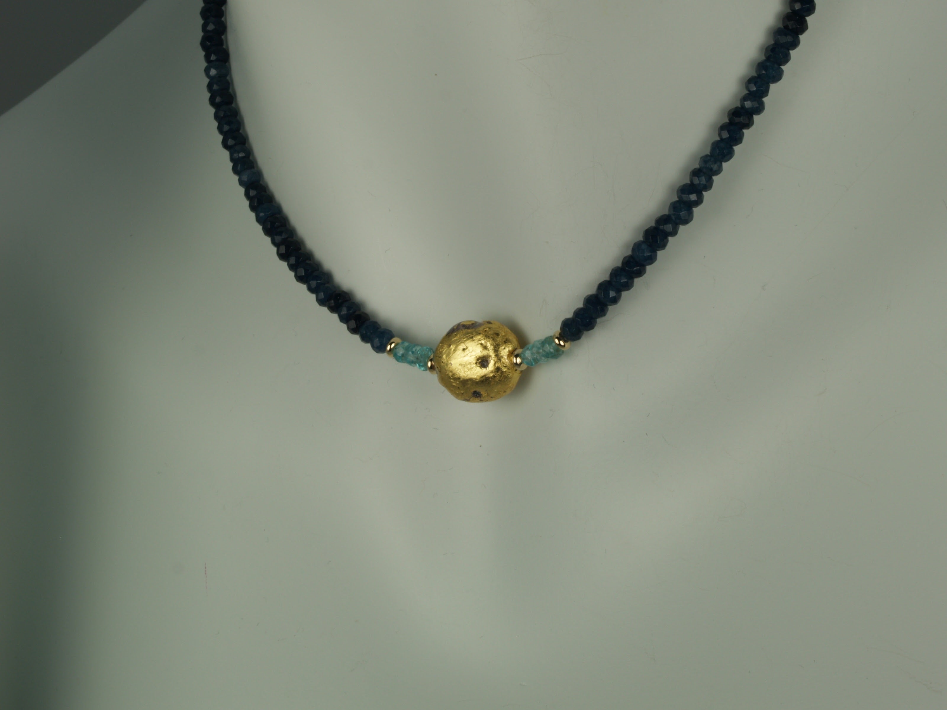 4mm sparkly faceted dark blue onyx, faceted aqua apatite, and gold gilded lava stone Necklace close up on mannequin neck