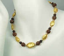 Load image into Gallery viewer, Hand made necklace with 23 karat gold gilded lava stones, lamp work bronze Czech glass, and 14 karat gold filled small round beads. The necklace is finished with 14 karat gold filled toggle clasp. The necklace is photographed on a white mannequin.