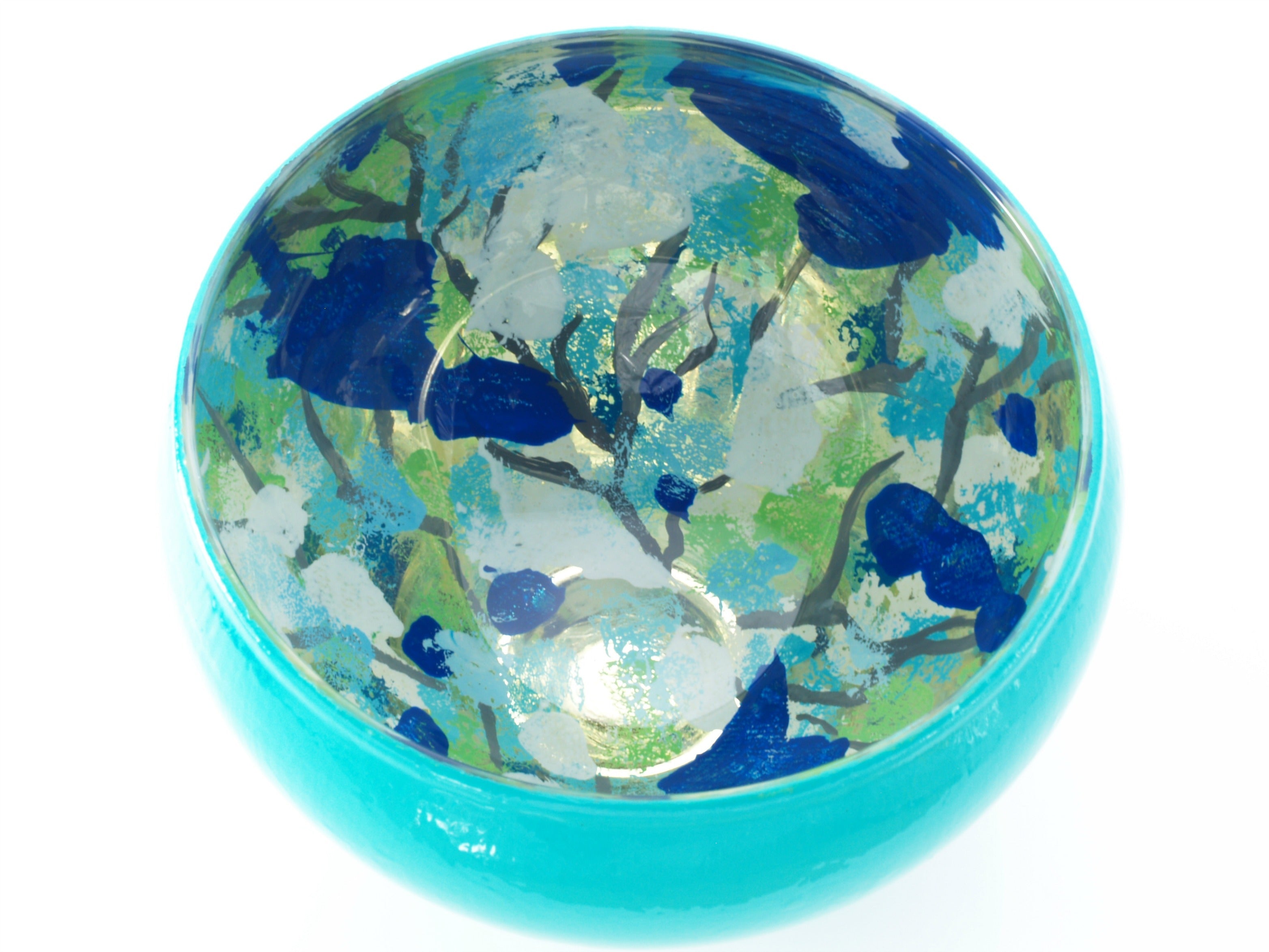 Blue, green, and turquoise design glass bowl on white background.