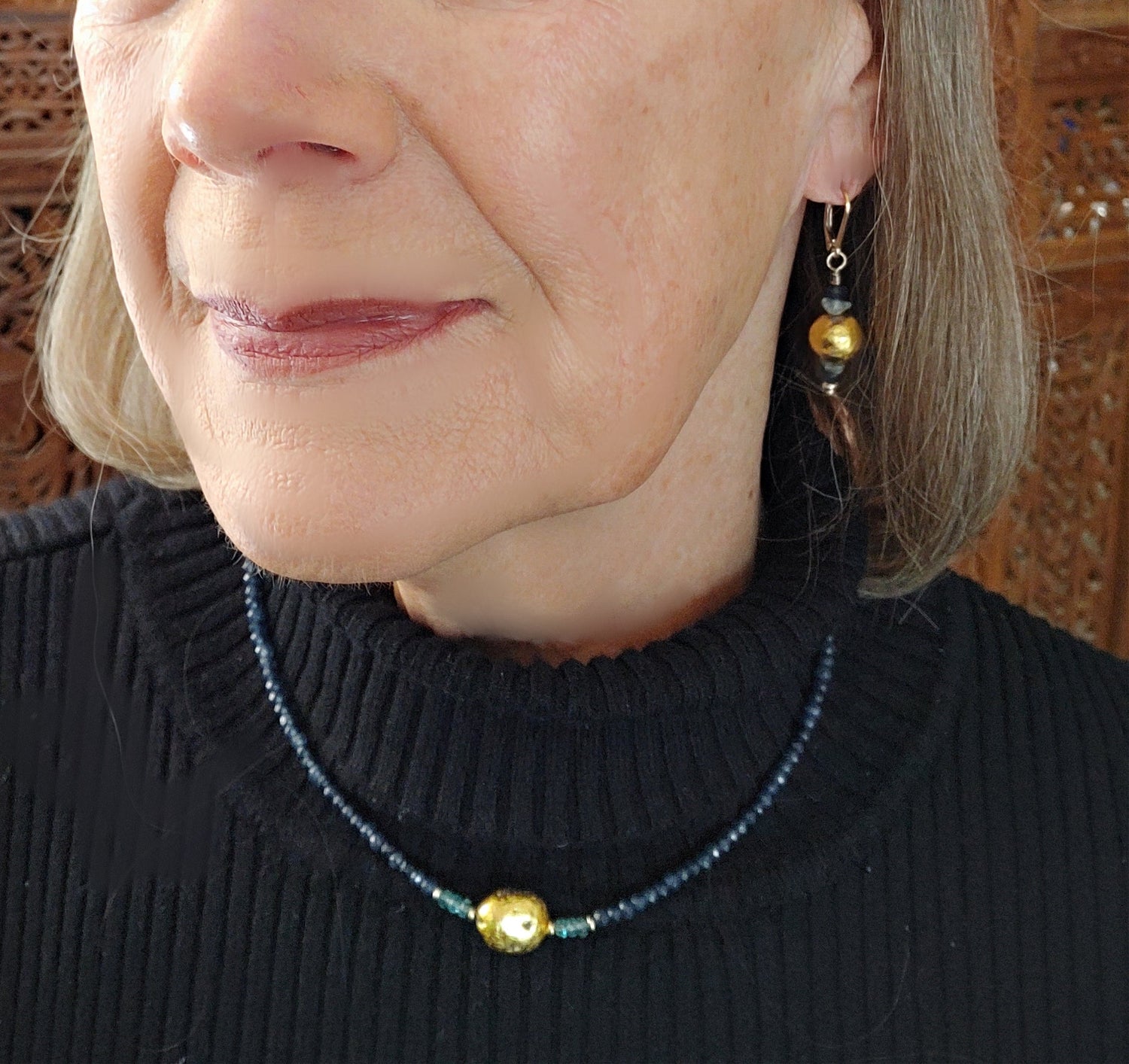 dark blue onyx, aqua apatite, and gold gilded lava stone Necklace and earrings shown close up on model