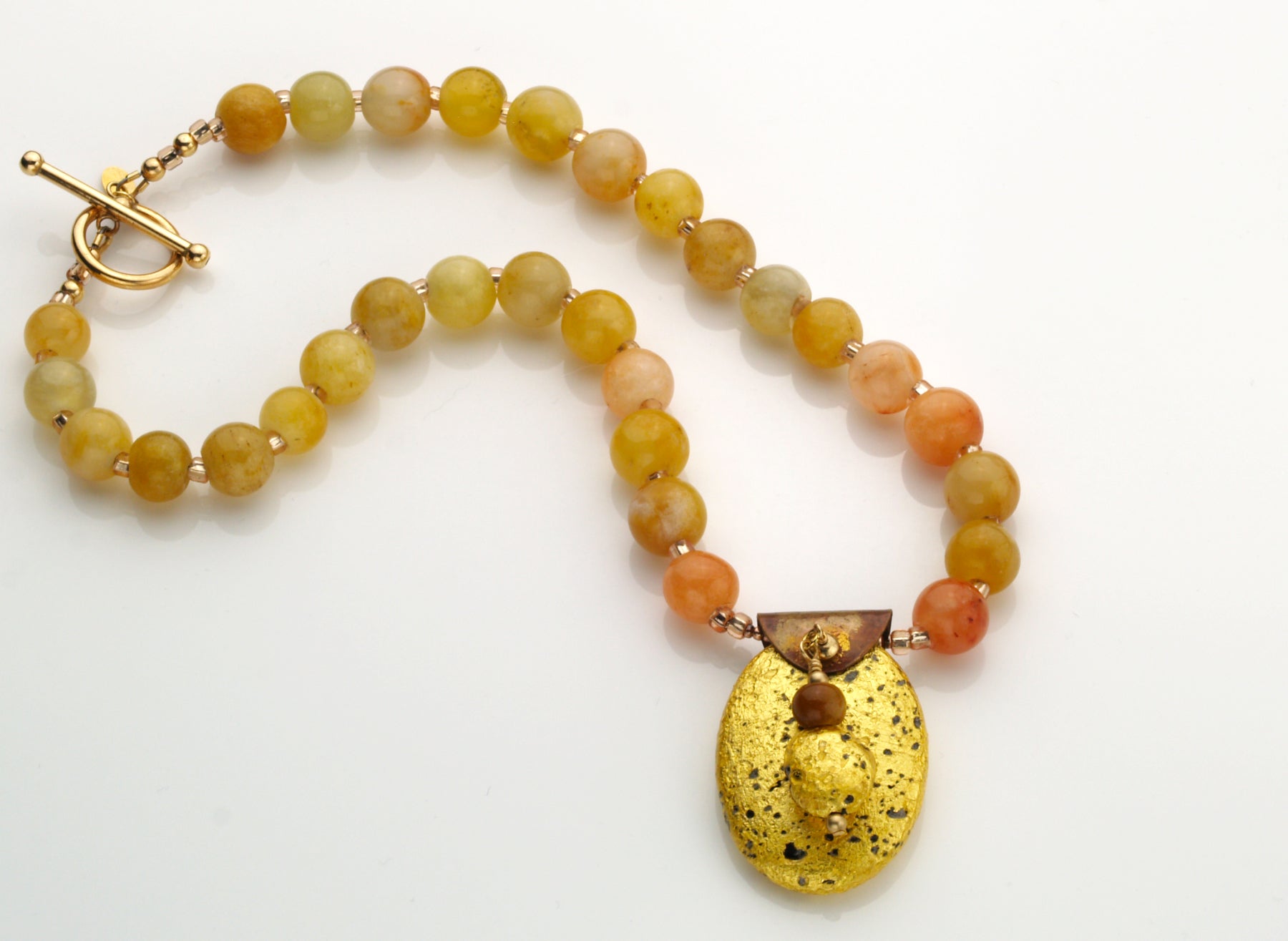gold gilded on lava pendant and yellow jade necklace