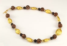 Load image into Gallery viewer, Hand made necklace with 23 karat gold gilded lava stones, lamp work bronze Czech glass, and 14 karat gold filled small round beads. The necklace is finished with 14 karat gold filled toggle clasp. The necklace is photographed facing to the right.