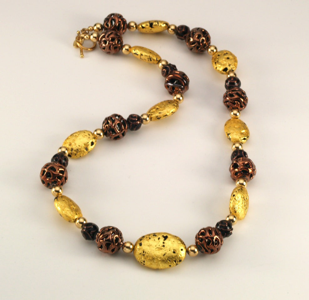 Hand made necklace with 23 karat gold gilded lava stones, lamp work bronze Czech glass, and 14 karat gold filled small round beads. The necklace is finished with 14 karat gold filled toggle clasp.