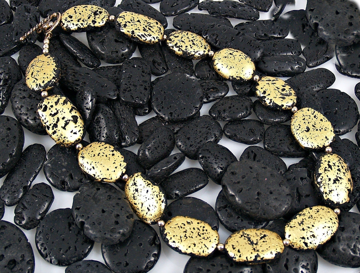 Gold gilded lava stones on top of black lava stones.