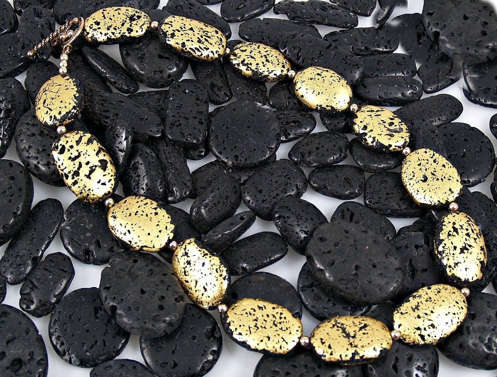 Gold gilded lava stones on top of black lava stones.