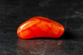 Red orange Carnelian stone on black background.