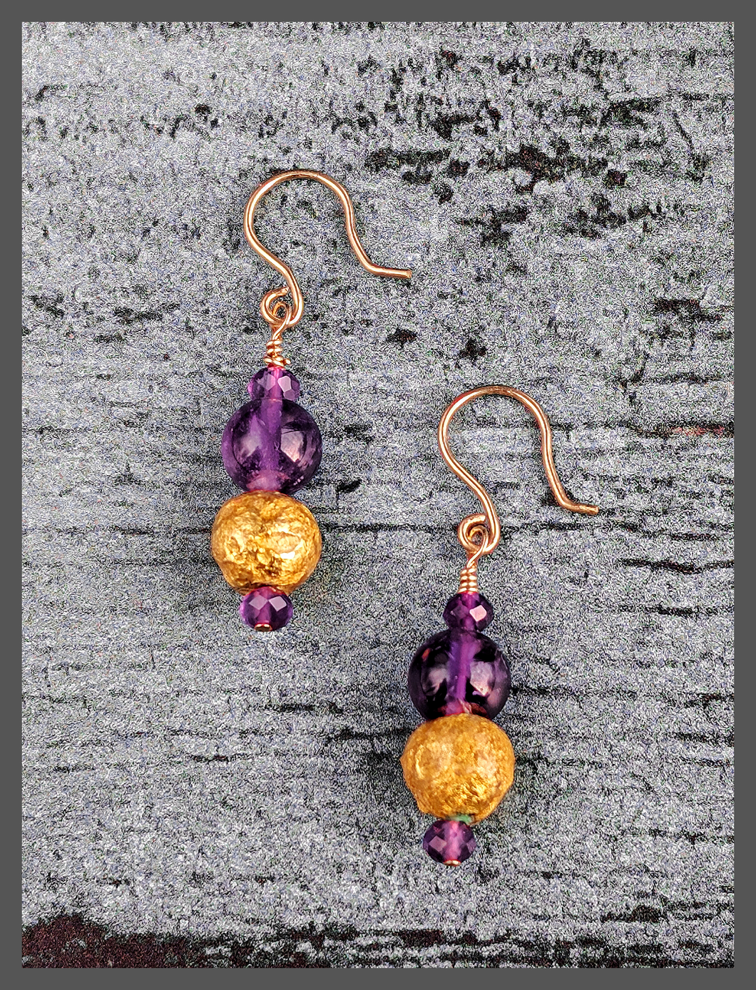 Amethyst Glow Earrings featuring faceted and smooth round  amethyst beads along with 23 karat hand gilded round lava stone. The earrings are 1.50