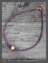 Load image into Gallery viewer, Amethyst Glow Necklace. Handcrafted with exquisite attention to detail, this elegant piece features stunning amethyst gemstones complemented by hand-gilded 23 karat gold leaf on lava stone center bead. It measures 17-inch in length and is finished with a 14 karat gold-filled toggle clasp.