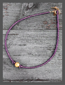 Amethyst Glow Necklace. Handcrafted with exquisite attention to detail, this elegant piece features stunning amethyst gemstones complemented by hand-gilded 23 karat gold leaf on lava stone center bead. It measures 17-inch in length and is finished with a 14 karat gold-filled toggle clasp.