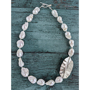 White Baroque pearl and silver necklace with hammered and fold form leaf design in silver with small silver beads in between each pearl. Necklace is finished with silver toggle clasp and designer tag.