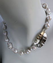 Load image into Gallery viewer, Featured on a white mannequin neck is a White Baroque pearl and silver necklace with hammered and fold form leaf design in silver with small silver beads in between each pearl. 