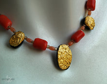 Load image into Gallery viewer, Close up of the gold and coral necklace on the white mannequin neck - Showing three of the gold gilded stones with four barrel shaped and oblong shaped coral stones. The small glass stones are also pictured inbetween all the other stones.