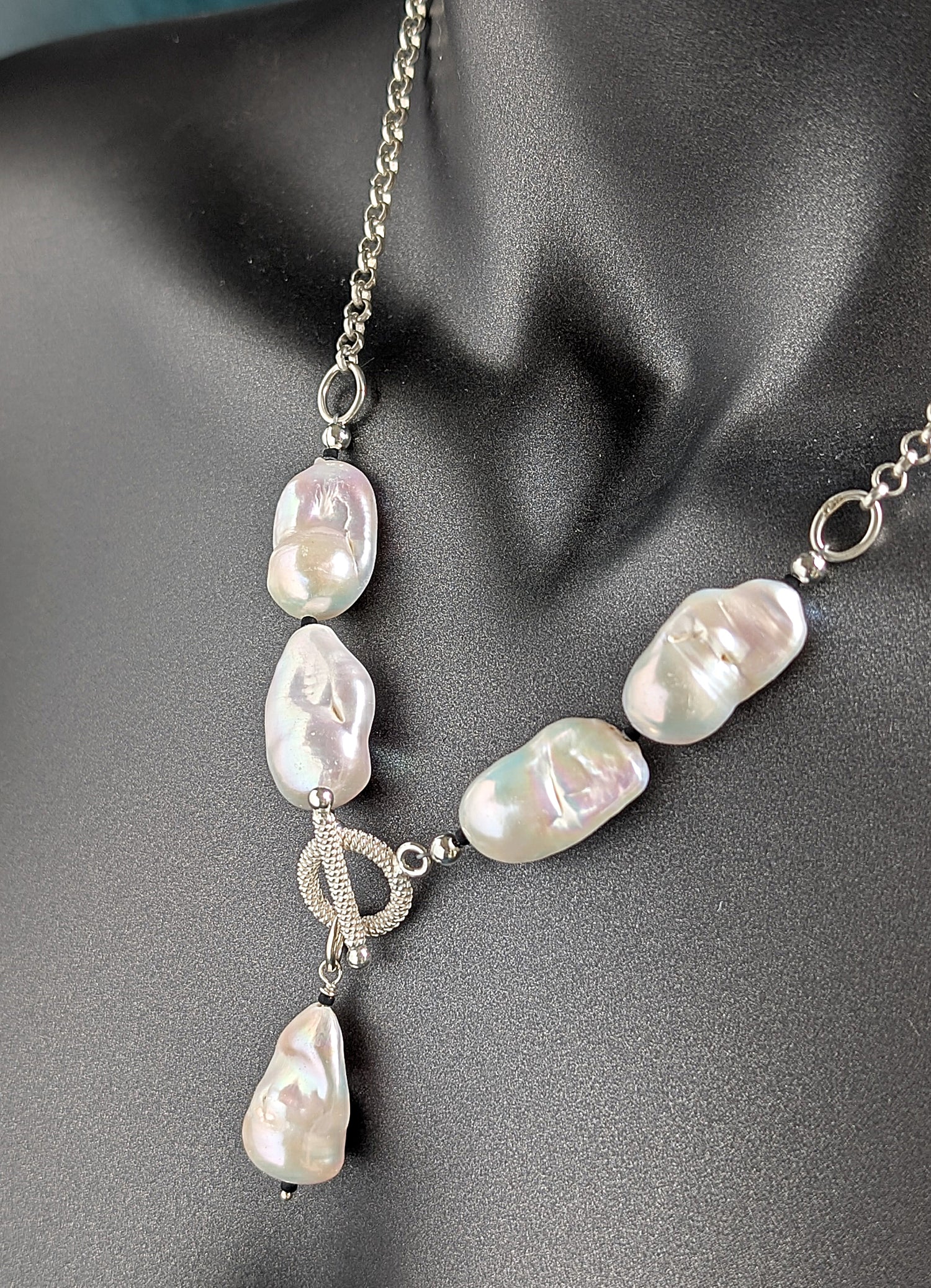 Pearl necklace with silver chain on a mannequin