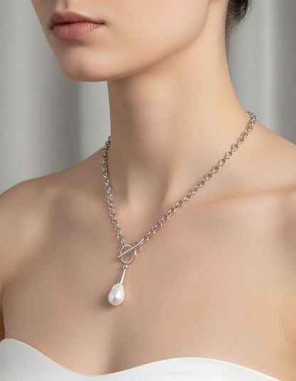 Necklace with a silver clasp and pearl pendant on a model.