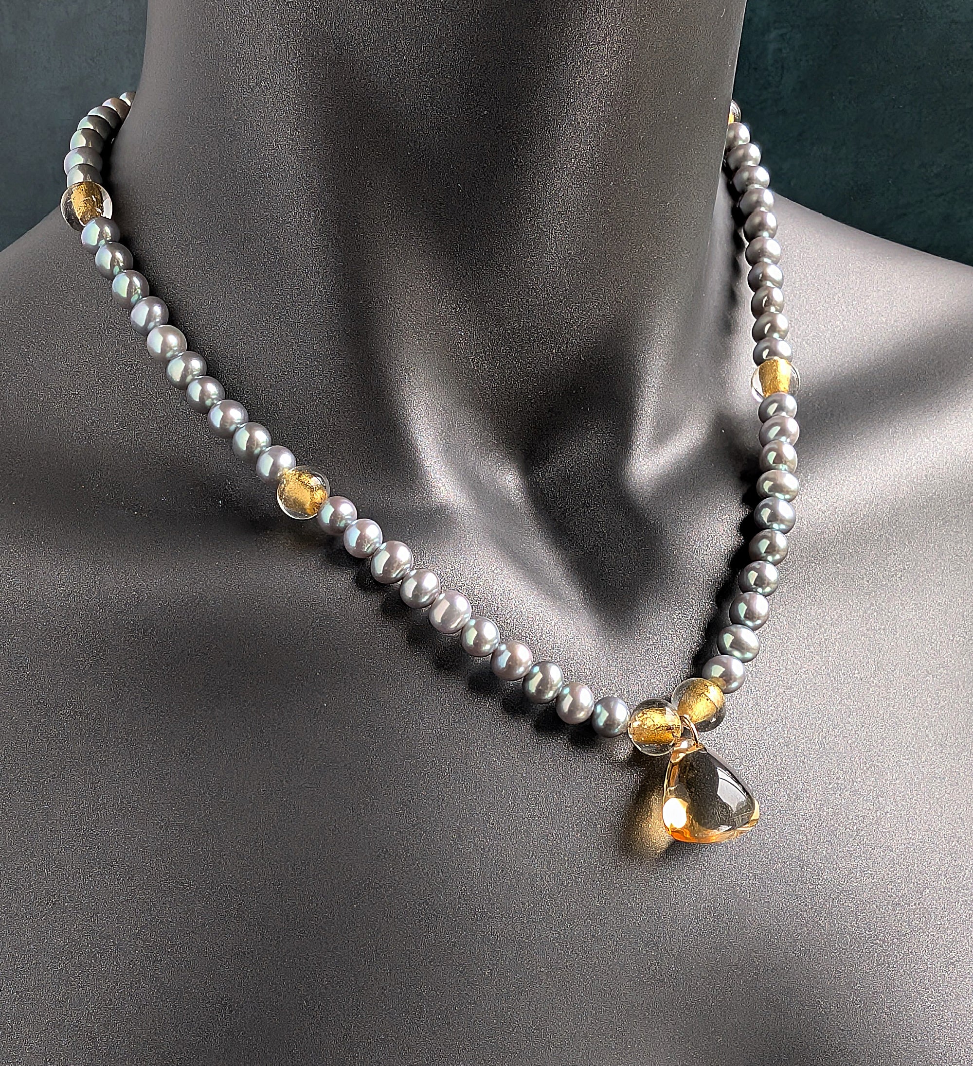 Gray Pearl and citrine necklace with gold accents on a mannequin