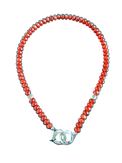 Red and silver necklace on a white background.