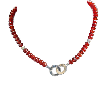 Necklace with red beads and a silver clasp on a white background