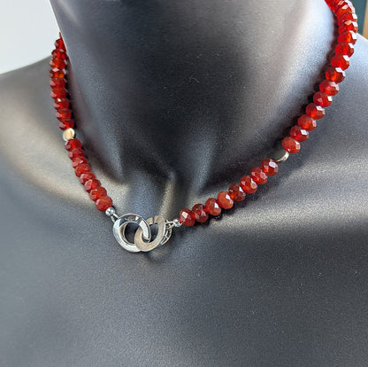 Necklace with red beads and silver clasp on a mannequin