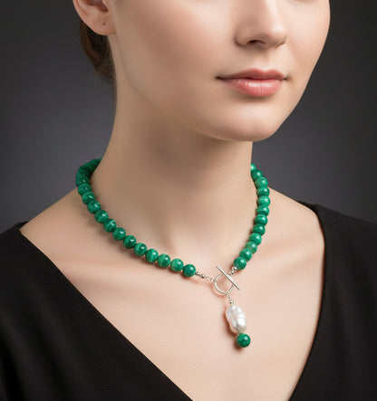 Green beaded necklace with a pearl pendant on a model.