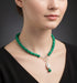 Green beaded necklace with a pearl pendant on a model.