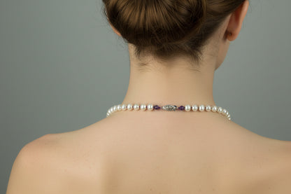 The back clasp on the Pearl necklace with purple beads on a model.