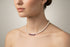 Pearl necklace with purple beads on a model.
