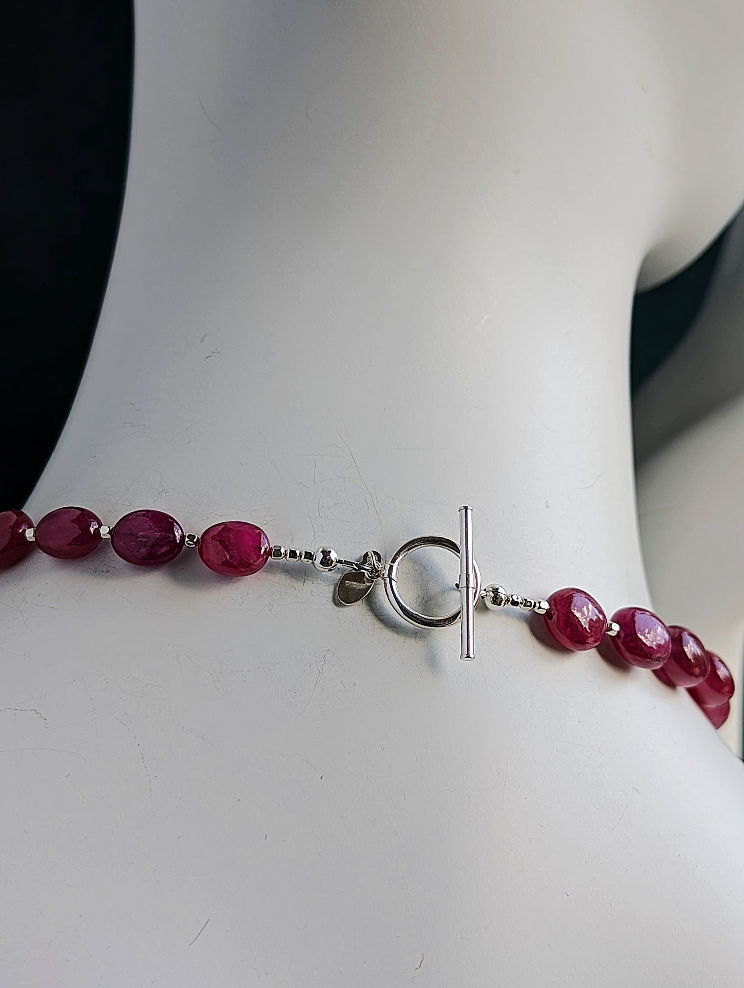 Showing the back of the ruby necklace with sterling silver toggle clasp on a mannequin neck.