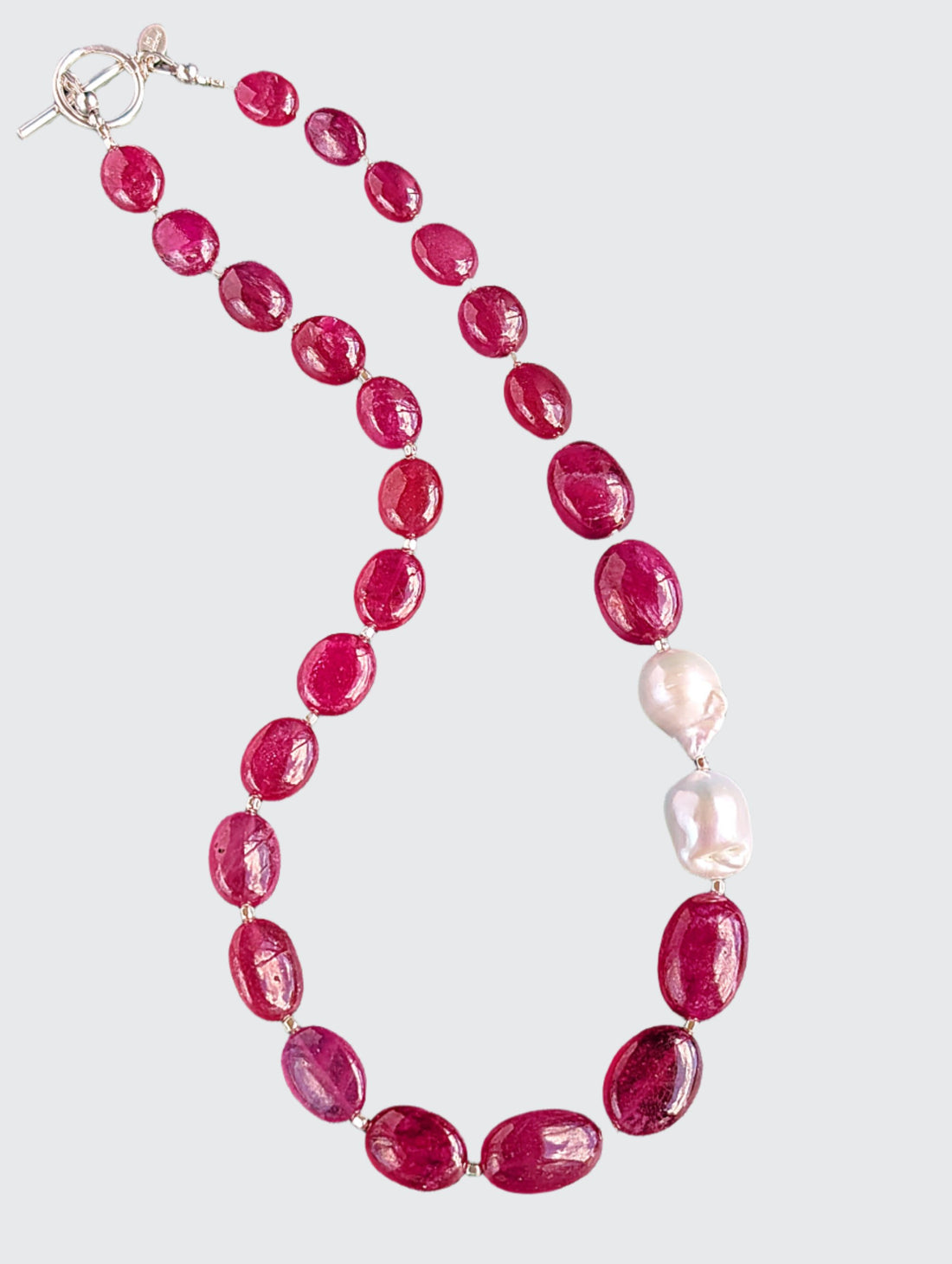 Ruby and Baroque Pearl Necklace - "Romancing the Ruby" necklace. This exquisite piece features cabochon smooth rubies, lustrous Baroque pearls, sterling silver beads, a charming toggle clasp, and a signature tag by the artist. With a length of 18 inches.
