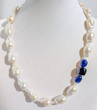 Load image into Gallery viewer, A close up of the baroque pearl, moonstone and sapphires on the necklace pictured on a display jewelry neck.