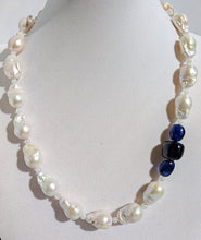 Load image into Gallery viewer, A close up of the baroque pearl, moonstone and sapphires on the necklace pictured on a display jewelry neck.