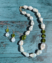 Load image into Gallery viewer, Baroque pearl, peridot and gold necklace measuring 19&quot;. The peridots are offset with three on one side of the necklace and one larger peridot on the opposite side. Between each pearl and peridot gem are 14 Karat gold beads and the necklace is finished with a 14 Karat hook and eye clasp. Matching dangle earrings are also pictured with the necklace.