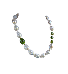 Baroque pearl, peridot and gold necklace measuring 19". The peridots are offset with three on one side of the necklace and one larger peridot on the opposite side. Between each pearl and peridot gem are 14 Karat gold beads. The necklace is pictured on white background.