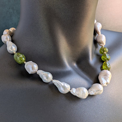 Necklace with white pearls and green beads on a dark surface