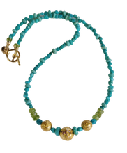 Load image into Gallery viewer, necklace with 24-Karat gold leaf on three round lava stones for centerpiece surrounded by turquoise beads, faceted peridot beads, and 14-Karat gold-filled Toggle Clasp along with designer signature tag