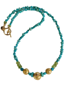 necklace with 24-Karat gold leaf on three round lava stones for centerpiece surrounded by turquoise beads, faceted peridot beads, and 14-Karat gold-filled Toggle Clasp along with designer signature tag